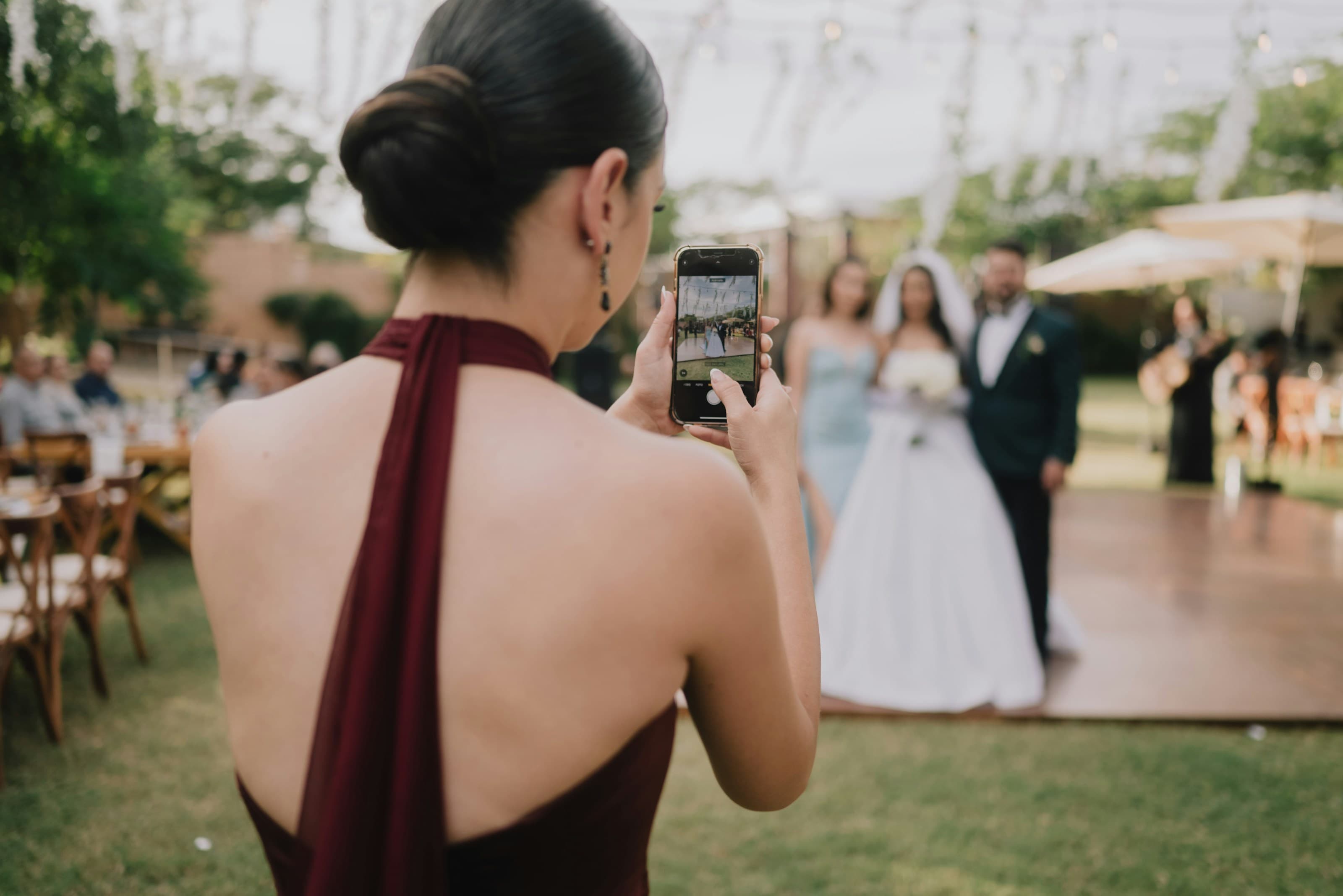 Wedding guests raising their phones to capture the couple during the reception